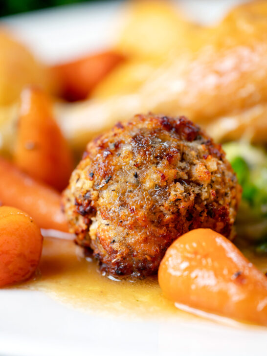 Close-up sage and onion stuffing balls as part of a Sunday lunch dinner.