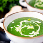 Spinach and fennel soup with fresh fennel fronds and bread.