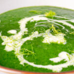 Close up verdant green spinach and fennel soup with fresh fennel fronds.