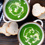 Overhead spinach and fennel soup with fresh fennel fronds and bread.