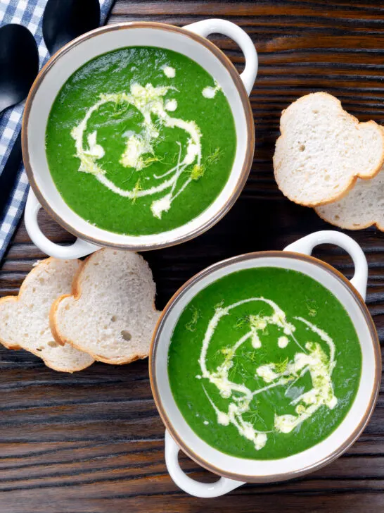 Overhead spinach and fennel soup with fresh fennel fronds and bread.