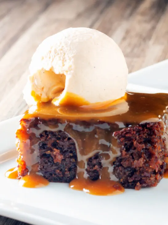 Sticky toffee pudding served with caramel sauce and vanilla ice cream.