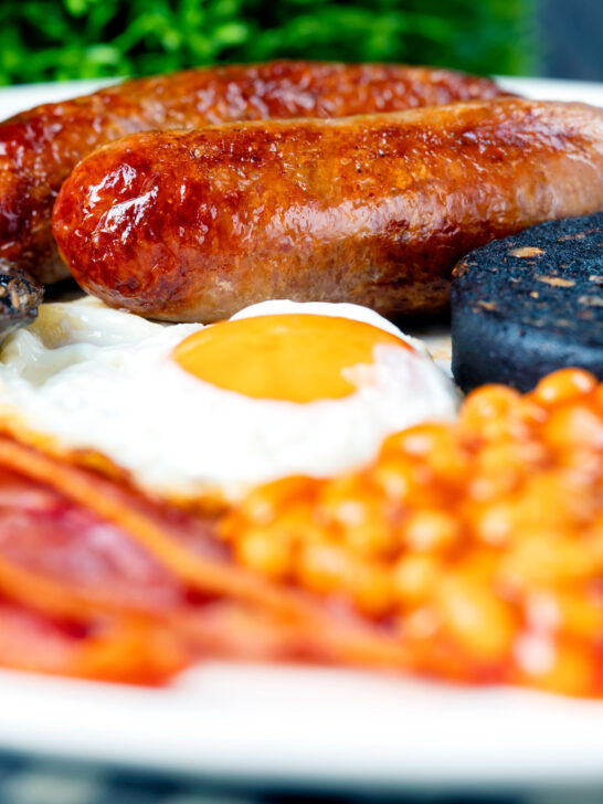 Close-up of sausages as part of full English fry up breakfast.