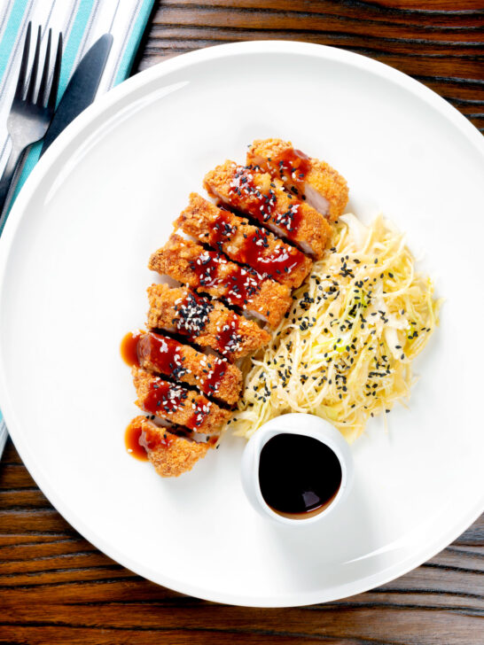 Overhead Japanese Tonkatsu pork cutlet served with katsu sauce and "soused" cabbage.