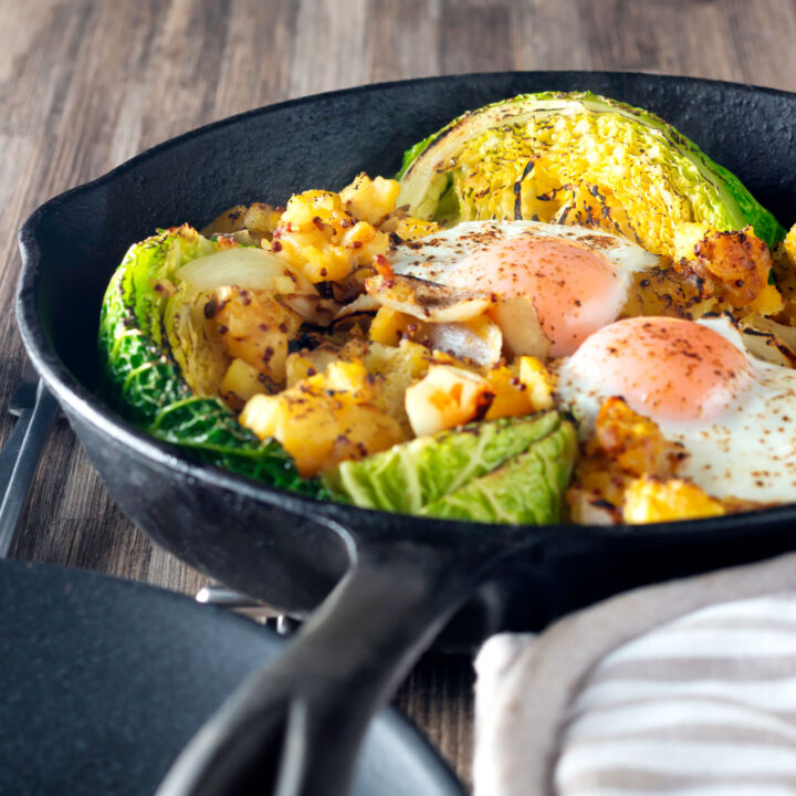 Vegetarian cabbage and potato bake with eggs roasted in a skillet.