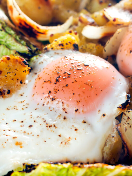 Close-up baked eggs in a a vegetarian left over cabbage and potato bake.