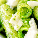 Close up wild garlic pesto served with rigatoni and gorgonzola cheese featuring a title overlay.