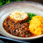 Mince and dumplings stew served with swede and carrot mash featuring a title overlay.