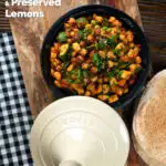 Overhead chickpea tagine with courgettes, harissa and preserved lemons served with flatbreads, featuring a title overlay.