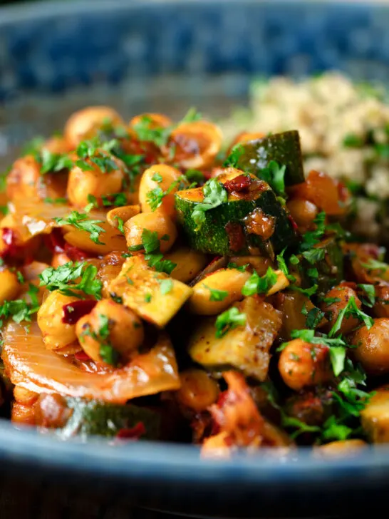 Close-up chickpea tagine with courgettes, harissa, almonds and preserved lemons.