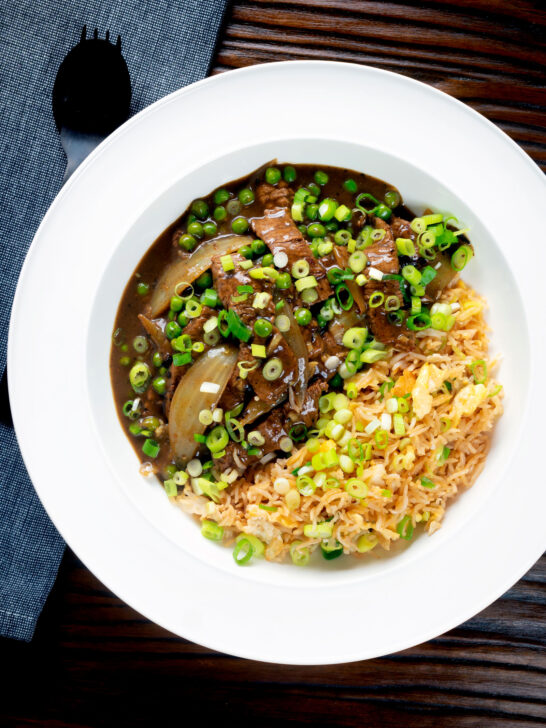 Overhead Chinese takeaway style beef curry served with egg fried rice.