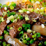 Close-up Chinese takeaway style beef curry served with egg fried rice.