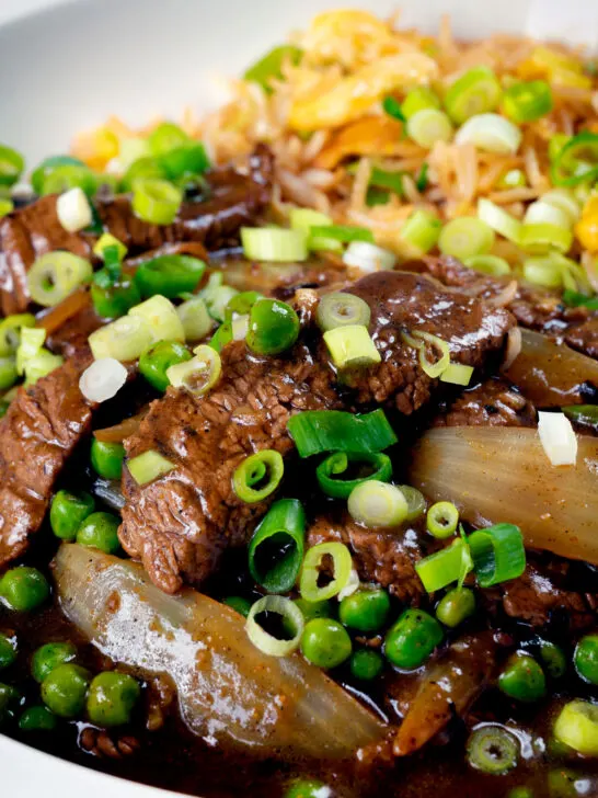 Close-up Chinese takeaway style beef curry served with egg fried rice.