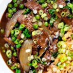Close-up overhead Chinese takeaway style beef curry served with egg fried rice.