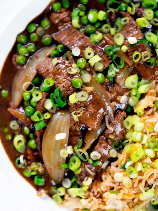 Close-up overhead Chinese takeaway style beef curry served with egg fried rice.