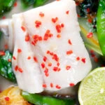 Close-up overhead cod loin poached in coconut milk.