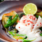 Poached cod loin in coconut milk with pak choi and chilli featuring a title overlay.