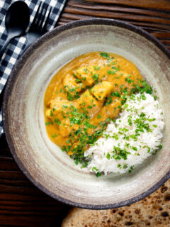 Overhead fruity pineapple and chicken curry with rice, coriander and naan.