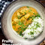 Overhead fruity pineapple and chicken curry with rice, coriander and naan featuring a title overlay.