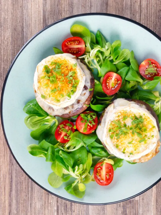 Overhead balsamic vinegar caramelised onion and goats cheese stuffed Portobello mushrooms.