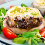 Close-up balsamic vingegar caramelised onion and goats cheese stuffed Portobello mushrooms.