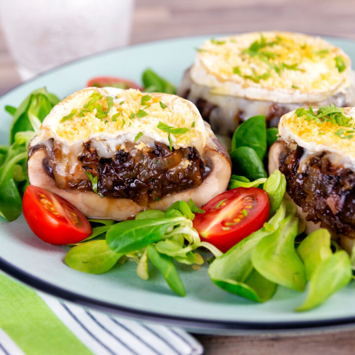 Goat cheese and caramelised onion stuffed Portobello mushrooms served with tomatoes and salad leaves.