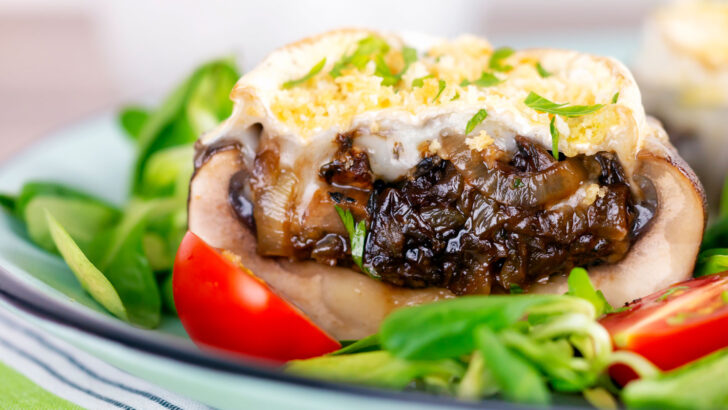 Goat cheese and caramelised onion stuffed Portobello mushrooms served with tomatoes and salad leaves.