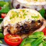 Goats cheese and caramelised onion stuffed mushrooms cut open to show filling.