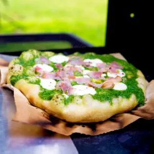 Goat cheese, bacon and rocket (arugula) pesto pizza.