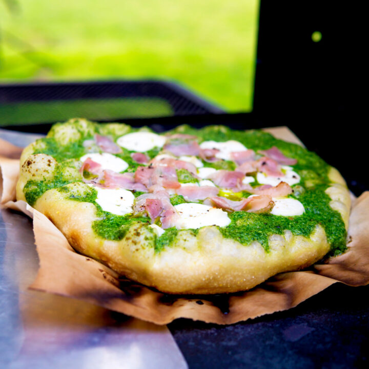 Goat cheese, bacon and rocket (arugula) pesto pizza.