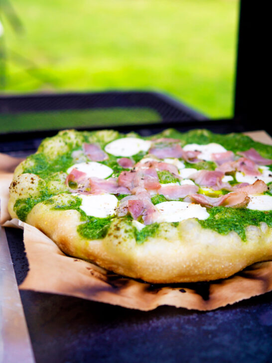 Thick crust goat cheese pizza with streaky bacon and rocket pesto.