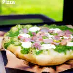 Thick crust goat cheese pizza with streaky bacon and rocket pesto featuring a title overlay.