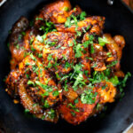 Overhead close-up spicy halloumi cheese curry with fresh coriander.