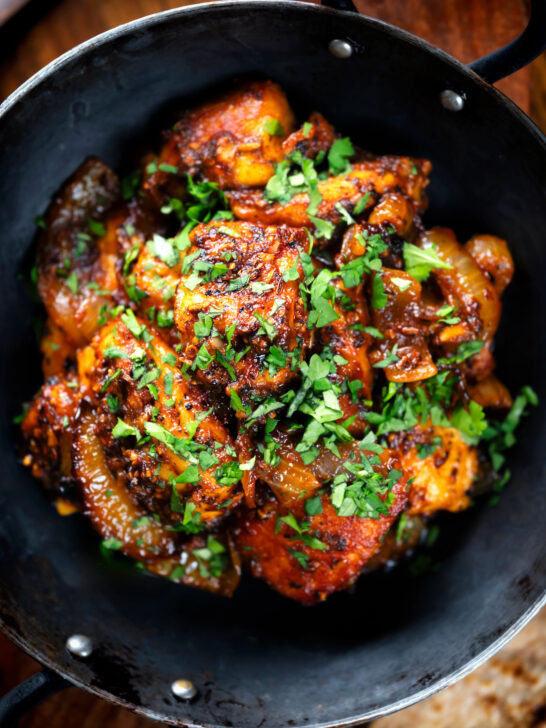 Overhead close-up spicy halloumi cheese curry with fresh coriander.