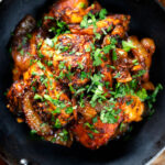 Overhead close-up spicy halloumi cheese curry with fresh coriander, featuring a title overlay.