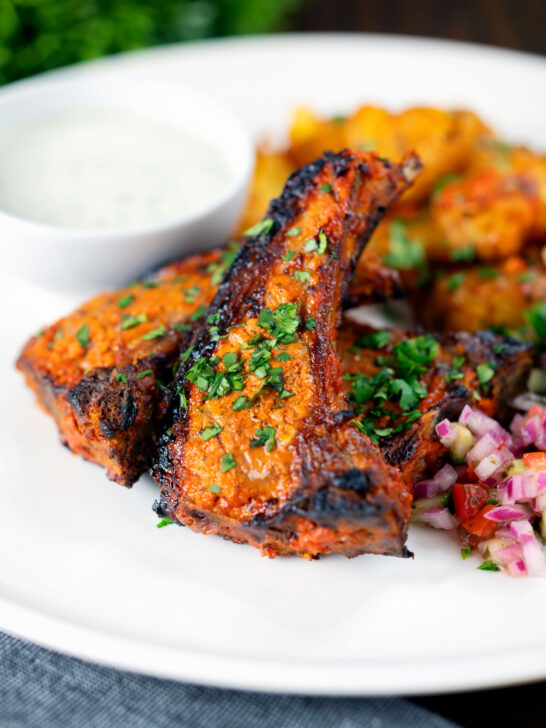 Tandoori lamb chops with roasted Bombay potatoes, raita and kachumber salad.