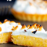 Individual lemon meringue pie with Italian meringue cut open to show filling featuring a title overlay.