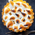 Overhead mini lemon meringue pie tartlet with Italian meringue.