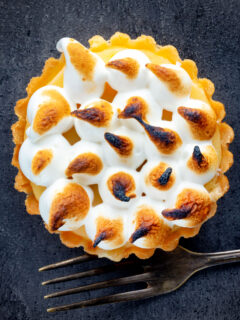 Overhead mini lemon meringue pie tartlet with Italian meringue.