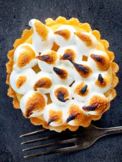 Overhead mini lemon meringue pie tartlet with Italian meringue.
