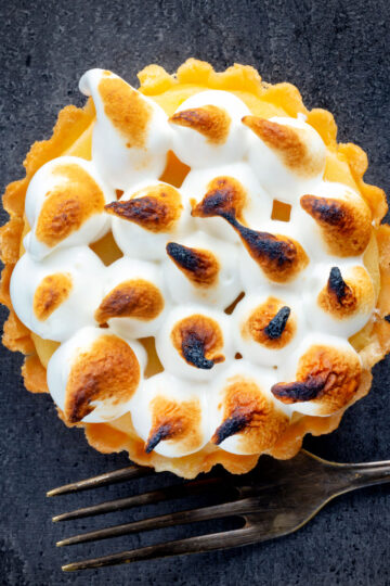 Overhead mini lemon meringue pie tartlet with Italian meringue.