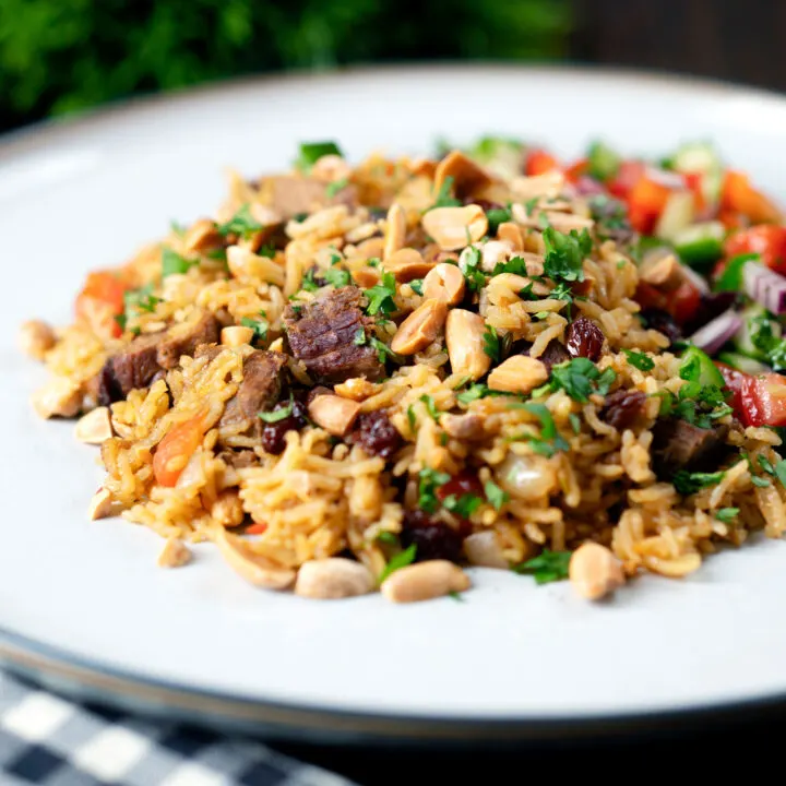 Lamb kabsa, one pot rice with raisins and almonds served with a chopped salad.