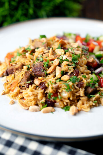 Lamb kabsa, Saudi Arabian rice with almonds and raisins served with chopped salad.