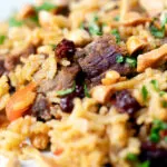 Close-up lamb kabsa, Saudi Arabian rice with almonds and raisins.