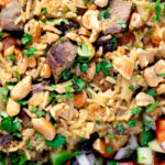 Overhead close-up lamb kabsa, Saudi Arabian rice with almonds and raisins.
