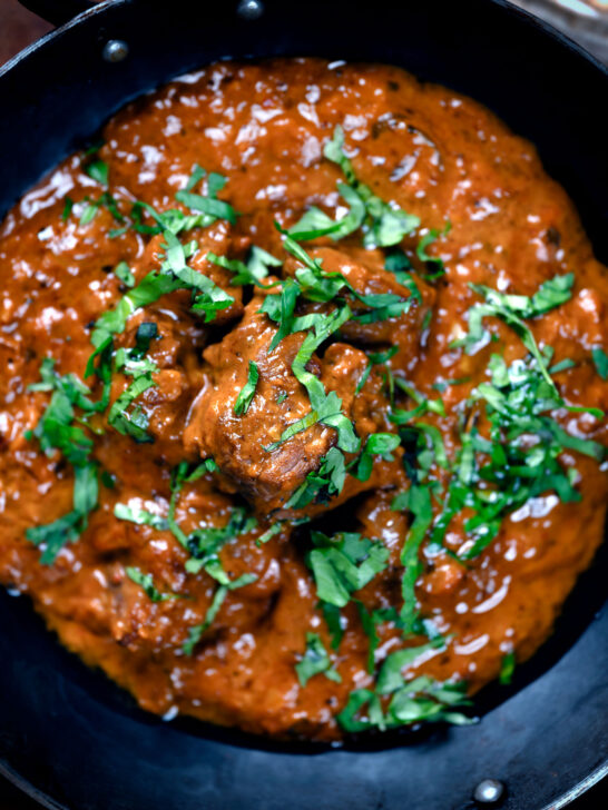 Overhead close-up lamb madras curry fakeaway with fresh coriander.