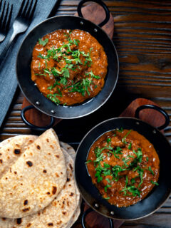 Overhead lamb madras curry fakeaway served with homemade chapatis.