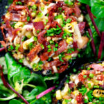 Overhead close-up bacon stuffed mushrooms with Lancashire cheese and snipped chives.