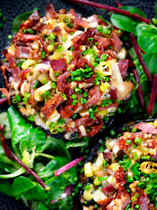 Overhead close-up bacon stuffed mushrooms with Lancashire cheese and snipped chives.