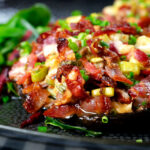 Close-up bacon stuffed mushrooms with Lancashire cheese and snipped chives.